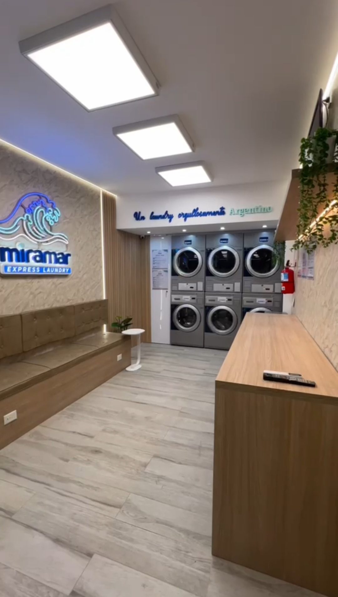 Interior de Miramar Express Laundry en Costa Rica 4778, Palermo, con las máquinas, un banco para esperar y una mesada